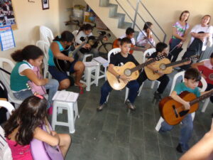 Aula de violão sendo mestrada para crianças na Escola de Choro Souza Eurico